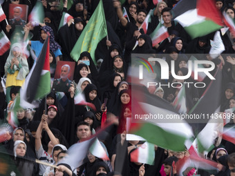 Veiled Iranian women and their families are waving Palestinian flags while participating in a family rally to support mandatory hijab at the...