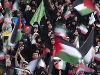 Veiled Iranian women and their families are waving Palestinian flags while participating in a family rally to support mandatory hijab at the...