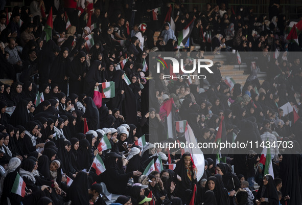 A young Iranian woman is adjusting her headscarf while participating in a family rally to support mandatory hijab, at the Azadi (Freedom) St...