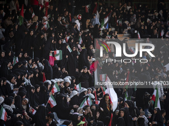 A young Iranian woman is adjusting her headscarf while participating in a family rally to support mandatory hijab, at the Azadi (Freedom) St...