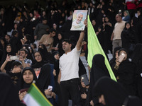 An Iranian man is holding up a portrait of former commander of the Islamic Revolutionary Guard Corps' (IRGC) Quds Force, Major General Qasse...