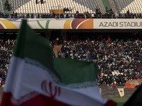 An Iranian flag is waving while veiled women and their families are participating in a family rally to support mandatory hijab, at the Azadi...