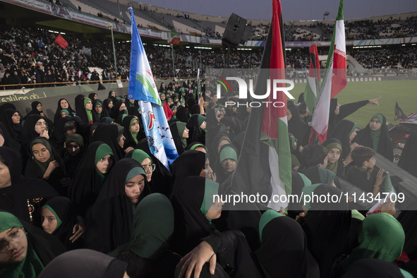 Young veiled women are carrying Iranian and Palestinian flags while they are participating in a family rally to support mandatory hijab at t...