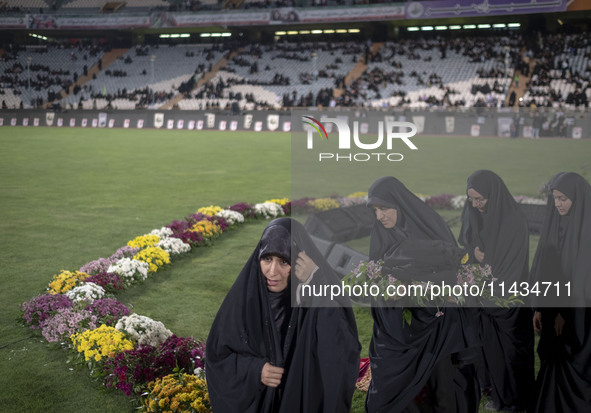 A group of veiled clergywomen are walking together after performing in a family rally to support mandatory hijab, at the Azadi (Freedom) Sta...