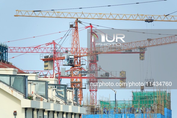 Tower cranes are being seen at a real estate construction site in Yantai, Shandong province, China, on July 23, 2024. On July 15, 2024, the...