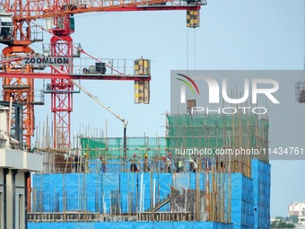 Tower cranes are being seen at a real estate construction site in Yantai, Shandong province, China, on July 23, 2024. On July 15, 2024, the...