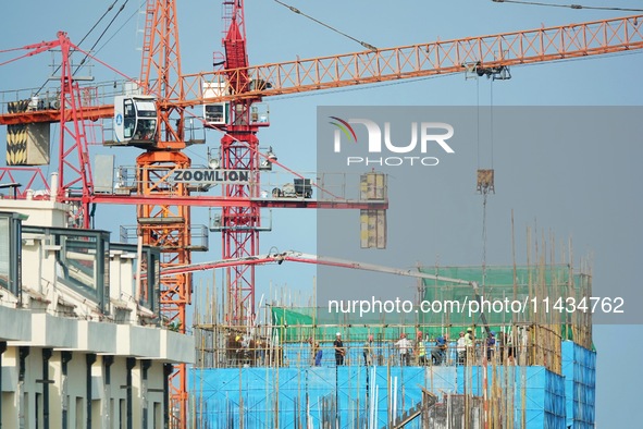 Tower cranes are being seen at a real estate construction site in Yantai, Shandong province, China, on July 23, 2024. On July 15, 2024, the...