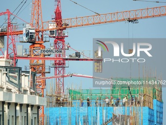 Tower cranes are being seen at a real estate construction site in Yantai, Shandong province, China, on July 23, 2024. On July 15, 2024, the...