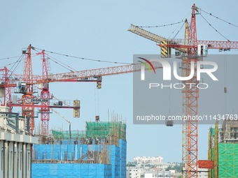 Tower cranes are being seen at a real estate construction site in Yantai, Shandong province, China, on July 23, 2024. On July 15, 2024, the...