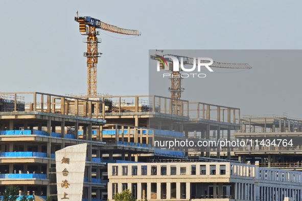 Tower cranes are being seen at a real estate construction site in Yantai, Shandong province, China, on July 23, 2024. On July 15, 2024, the...