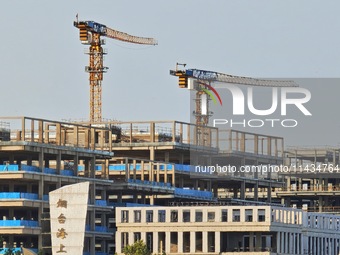 Tower cranes are being seen at a real estate construction site in Yantai, Shandong province, China, on July 23, 2024. On July 15, 2024, the...