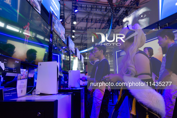 A cosplayer is playing games at the PlayStation game booth during the Chinajoy games fair in Shanghai, China, on July 26, 2024. 