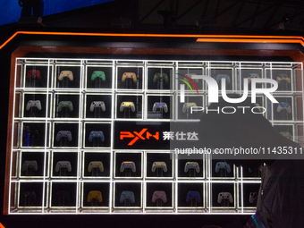 A man is standing in front of PXN games controllers at the PXN booth during the Chinajoy games fair in Shanghai, China, on July 26, 2024. (