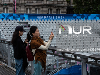 Few tourists are holding tickets for the opening ceremony of the Olympic Games in the center of Paris, France, on the banks of the Seine, in...