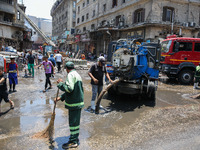 Workers are cleaning up the streets after the firefighters of the Civil Defense are controlling a huge fire that broke out in several stores...