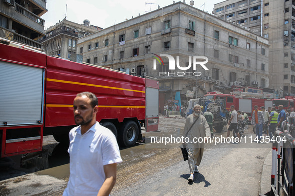 Pedestrians are in the street after the firefighters of the Civil Defense are controlling a huge fire that broke out in several stores, in M...