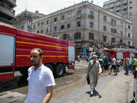 Pedestrians are in the street after the firefighters of the Civil Defense are controlling a huge fire that broke out in several stores, in M...