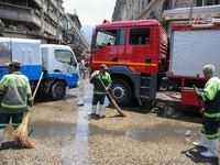 Workers are cleaning up the streets after the firefighters of the Civil Defense are controlling a huge fire that broke out in several stores...