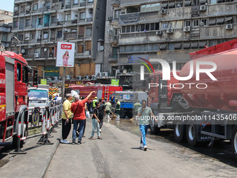 Pedestrians are in the street after the firefighters of the Civil Defense are controlling a huge fire that broke out in several stores, in M...