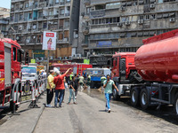 Pedestrians are in the street after the firefighters of the Civil Defense are controlling a huge fire that broke out in several stores, in M...