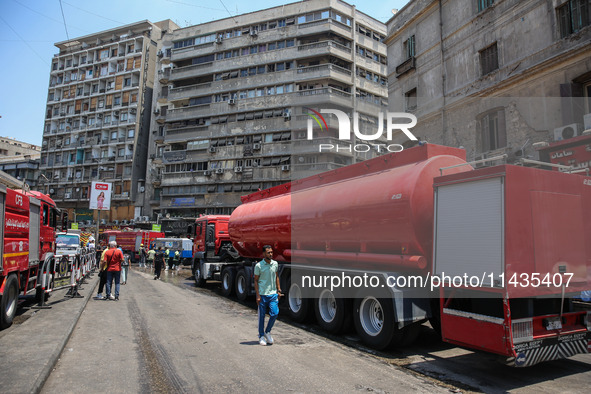 Pedestrians are in the street after the firefighters of the Civil Defense are controlling a huge fire that broke out in several stores, in M...