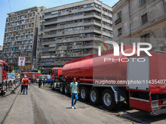 Pedestrians are in the street after the firefighters of the Civil Defense are controlling a huge fire that broke out in several stores, in M...