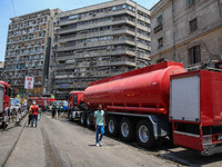 Pedestrians are in the street after the firefighters of the Civil Defense are controlling a huge fire that broke out in several stores, in M...