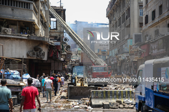 Pedestrians are in the street after the firefighters of the Civil Defense are controlling a huge fire that broke out in several stores, in M...