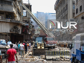 Pedestrians are in the street after the firefighters of the Civil Defense are controlling a huge fire that broke out in several stores, in M...