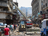 Pedestrians are in the street after the firefighters of the Civil Defense are controlling a huge fire that broke out in several stores, in M...