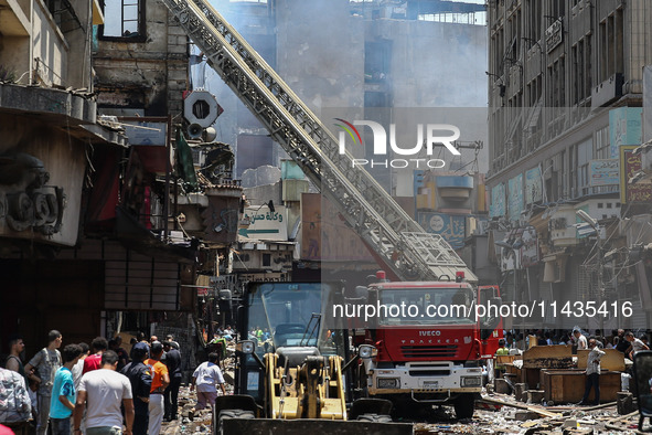 Pedestrians are in the street after the firefighters of the Civil Defense are controlling a huge fire that broke out in several stores, in M...