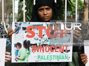 A member of the Indians for Palestine group is holding a poster during a protest, amid the ongoing conflict in Gaza between Israel and Hamas...