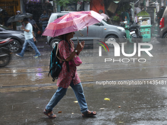 A woman with an umbrella is walking on a road during heavy monsoon rain in Kolkata, India, on July 26, 2024. (