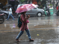 A woman with an umbrella is walking on a road during heavy monsoon rain in Kolkata, India, on July 26, 2024. (