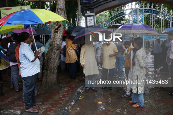 Indians for Palestine group members are holding umbrellas during monsoon rain as they are waiting to start a protest, amid the ongoing confl...