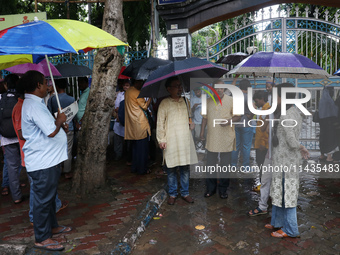 Indians for Palestine group members are holding umbrellas during monsoon rain as they are waiting to start a protest, amid the ongoing confl...