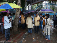 Indians for Palestine group members are holding umbrellas during monsoon rain as they are waiting to start a protest, amid the ongoing confl...