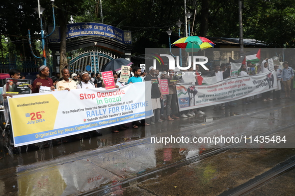 Indians for Palestine group members are holding posters during a protest, amid the ongoing conflict in Gaza between Israel and Hamas, in Kol...