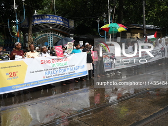 Indians for Palestine group members are holding posters during a protest, amid the ongoing conflict in Gaza between Israel and Hamas, in Kol...