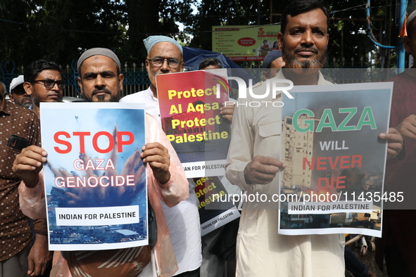 Indians for Palestine group members are holding posters during a protest, amid the ongoing conflict in Gaza between Israel and Hamas, in Kol...