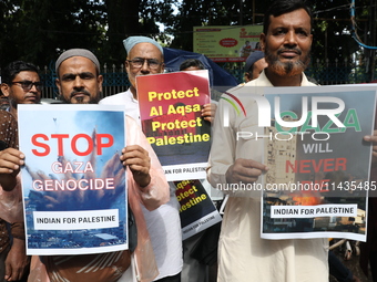 Indians for Palestine group members are holding posters during a protest, amid the ongoing conflict in Gaza between Israel and Hamas, in Kol...