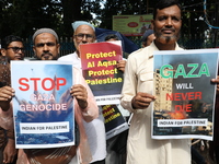 Indians for Palestine group members are holding posters during a protest, amid the ongoing conflict in Gaza between Israel and Hamas, in Kol...