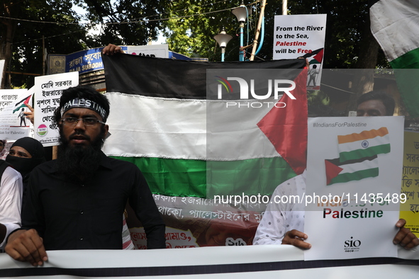 Indians for Palestine group members are holding posters during a protest, amid the ongoing conflict in Gaza between Israel and Hamas, in Kol...