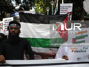 Indians for Palestine group members are holding posters during a protest, amid the ongoing conflict in Gaza between Israel and Hamas, in Kol...