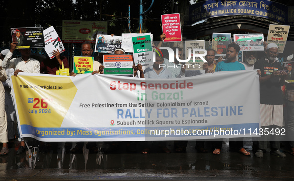 Indians for Palestine group members are holding posters during a protest, amid the ongoing conflict in Gaza between Israel and Hamas, in Kol...