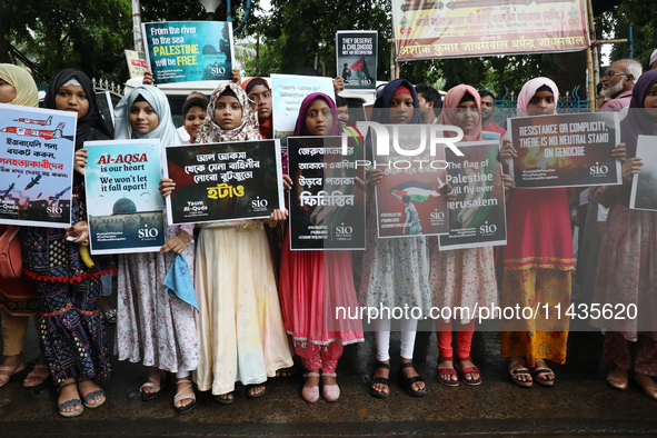 Indians for Palestine group members are holding posters during a protest, amid the ongoing conflict in Gaza between Israel and Hamas, in Kol...