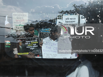 A woman is looking from a moving car window as Indians for Palestine group members are holding posters during a protest, amid the ongoing co...