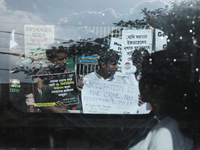 A woman is looking from a moving car window as Indians for Palestine group members are holding posters during a protest, amid the ongoing co...