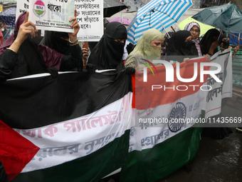 Muslim women wearing hijabs are holding posters and shouting slogans during a protest rally, amid the ongoing conflict in Gaza between Israe...