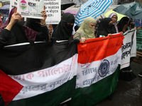 Muslim women wearing hijabs are holding posters and shouting slogans during a protest rally, amid the ongoing conflict in Gaza between Israe...